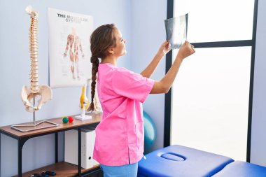 Genç, İspanyol bir fizyoterapist. Rehabilitasyon kliniğinde kendinden emin bir şekilde gülümsüyor.