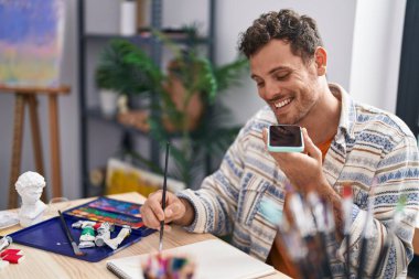 Genç İspanyol ressam, resim stüdyosunda akıllı telefon çizimleriyle konuşuyor.