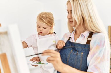 Mother and daughter concentrate drawing at art studio