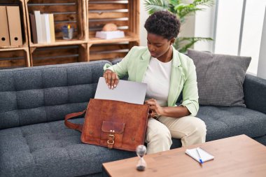 Psikoloji merkezinde çantanın dizüstü bilgisayarını tutan Afrikalı Amerikalı kadın psikolog.