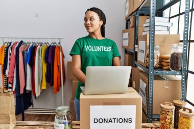 Gönüllü üniforma giyen genç Afro-Amerikan kadın hayır kurumunda çalışıyor.