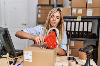 Genç sarışın kadın ecommerce iş işçisi ofiste paket paketleme