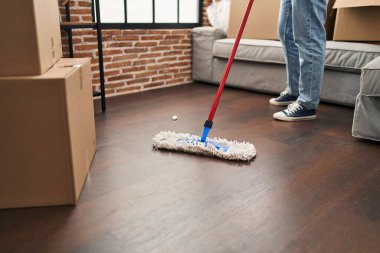 Young arab man cleaning floor at new home