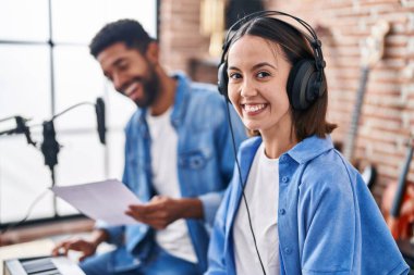 Man and woman musicians singing song playing piano at music studio