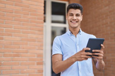 Sokakta dokunmatik ped kullanan, kendine güvenen İspanyol genç adam.