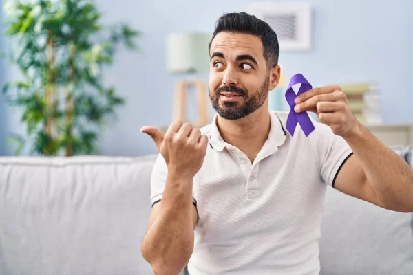 Young Hispanic Man Beard Holding Purple Ribbon Awareness Pointing Thumb — Stock Photo, Image