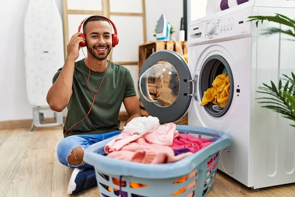 Young Hispanic Man Listening Music Using Washing Machine Laundry — Stockfoto