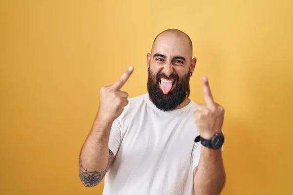 Young Hispanic Man Beard Tattoos Standing Yellow Background Showing Middle —  Fotos de Stock