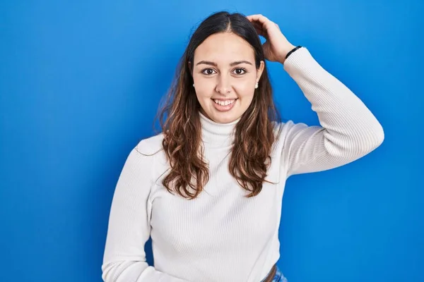 Young Hispanic Woman Standing Blue Background Smiling Confident Touching Hair — Foto Stock