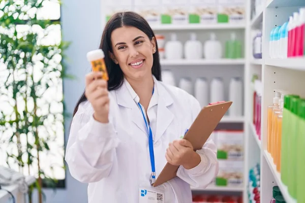 Young Beautiful Hispanic Woman Pharmacist Holding Pills Bottle Reading Document — Stock Photo, Image