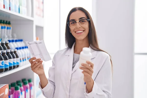 Young Beautiful Hispanic Woman Pharmacist Holding Pills Bottle Reading Prescription — Stock Photo, Image