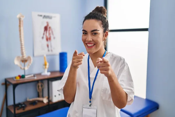 Young Hispanic Woman Working Rehabilitation Clinic Pointing Fingers Camera Happy — Fotografia de Stock