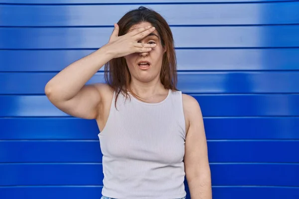 Brunette Woman Standing Blue Background Peeking Shock Covering Face Eyes — Photo