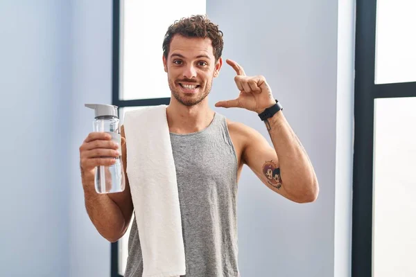 Jonge Spaanse Man Draagt Sportkleding Drinkwater Glimlachend Zelfverzekerd Gebaar Met — Stockfoto