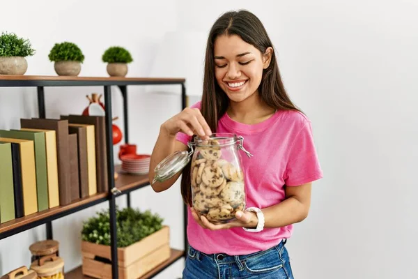 Junge Lateinische Frau Lächelt Selbstbewusst Und Isst Kekse Hause — Stockfoto