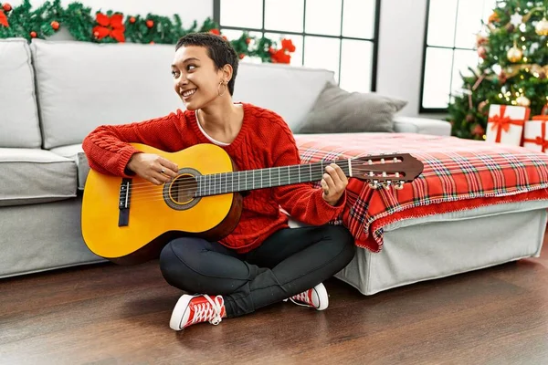 Jovem Hispânica Tocando Guitarra Clássica Sentada Árvore Natal Casa — Fotografia de Stock