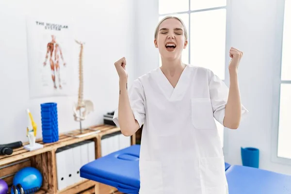 Mulher Caucasiana Jovem Trabalhando Clínica Recuperação Dor Comemorando Surpreso Surpreso — Fotografia de Stock