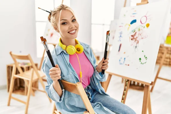 年轻的高加索女艺术家微笑着 自信地在艺术工作室拿着画笔 — 图库照片