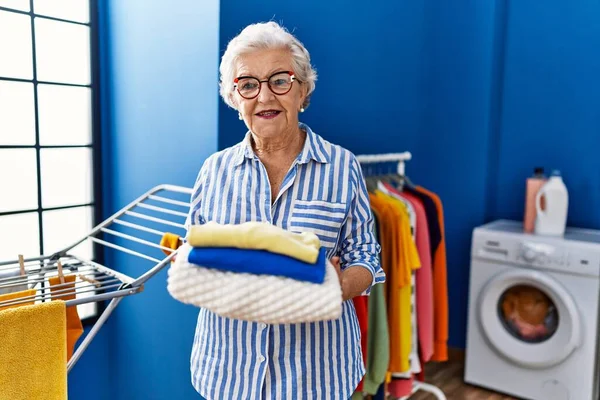 Senior Mujer Pelo Gris Sonriendo Confiado Sosteniendo Ropa Doblada Lavandería — Foto de Stock