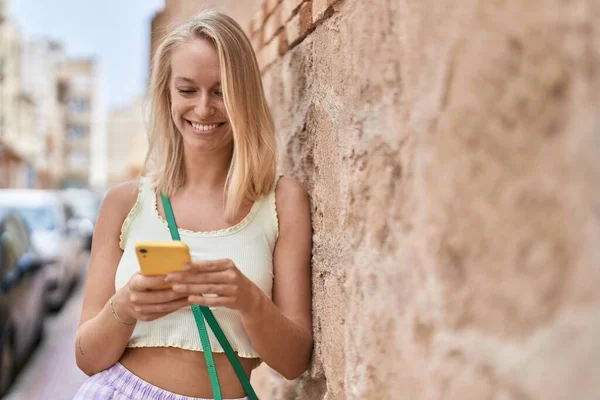 Νεαρή Ξανθιά Γυναίκα Χαμογελά Αυτοπεποίθηση Χρησιμοποιώντας Smartphone Στο Δρόμο — Φωτογραφία Αρχείου
