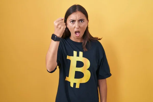 Young Hispanic Woman Wearing Bitcoin Shirt Angry Mad Raising Fist — Zdjęcie stockowe