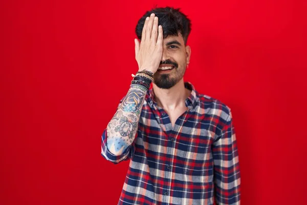 Young Hispanic Man Beard Standing Red Background Covering One Eye — Stock Photo, Image