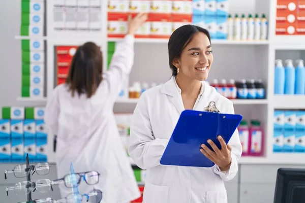 Two Women Pharmacist Smiling Confident Writing Document Pharmacy — Foto de Stock