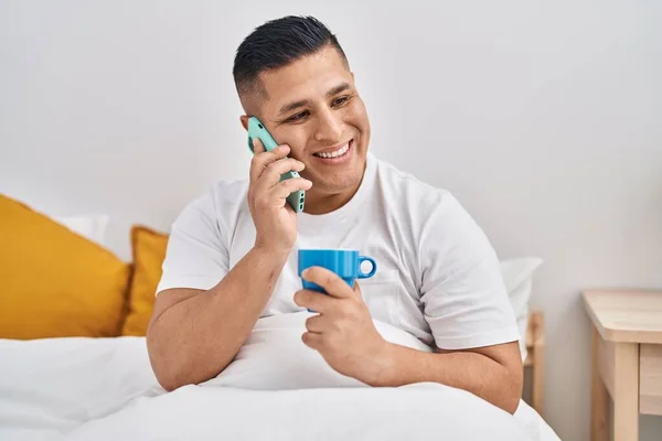 Genç Latin Adam Akıllı Telefonda Konuşuyor Yatak Odasında Kahve Içiyor — Stok fotoğraf