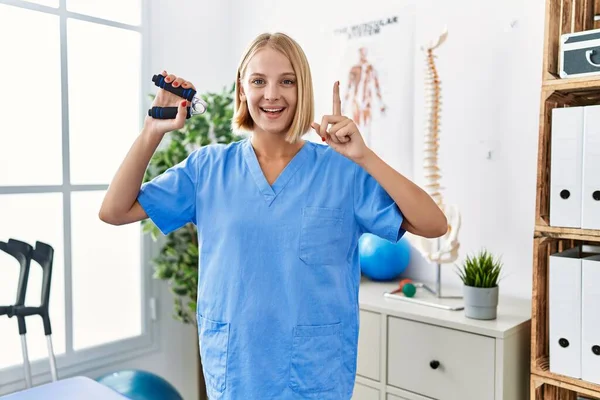 Young Caucasian Physiotherapist Woman Holding Hand Grip Train Muscle Smiling — Stockfoto