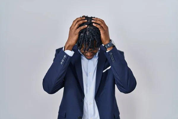 Young african man with dreadlocks wearing business jacket over white background suffering from headache desperate and stressed because pain and migraine. hands on head.