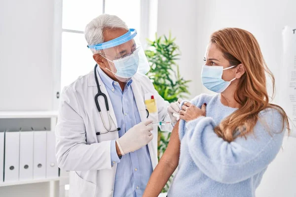 Lekarz Średnim Wieku Noszący Maskę Medyczną Szczepiący Pacjenta Klinice — Zdjęcie stockowe