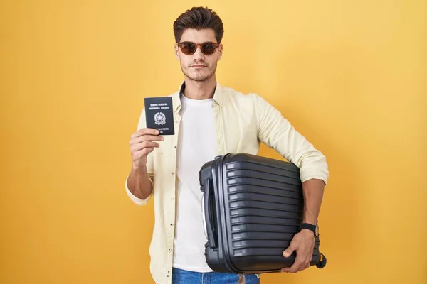 持有意大利护照的年轻人提着手提箱去度假 脸上带着严肃的表情放松了下来 简单而自然地看着相机 — 图库照片