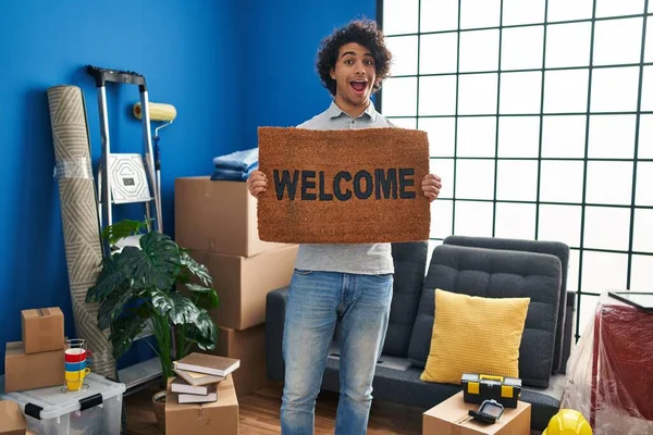 Hispanic Man Curly Hair Holding Welcome Doormat Celebrating Crazy Amazed — Stock Photo, Image