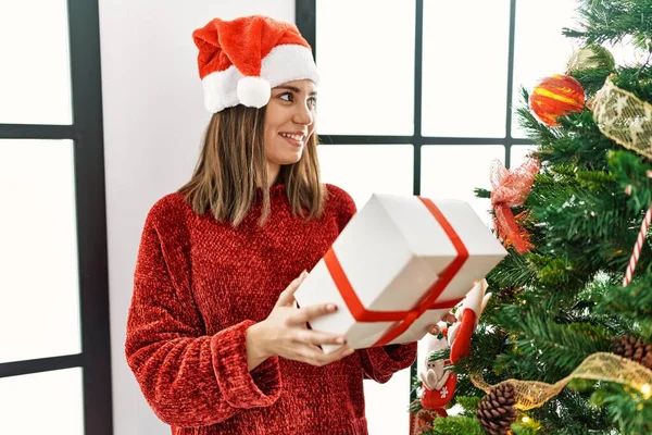 Young Hispanic Girl Holding Gift Standing Christmas Tree Home — Stock Photo, Image