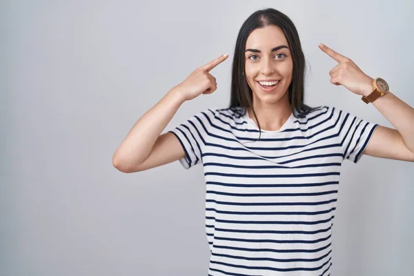 Mujer Morena Joven Con Camiseta Rayada Sonriendo Apuntando Cabeza Con —  Fotos de Stock