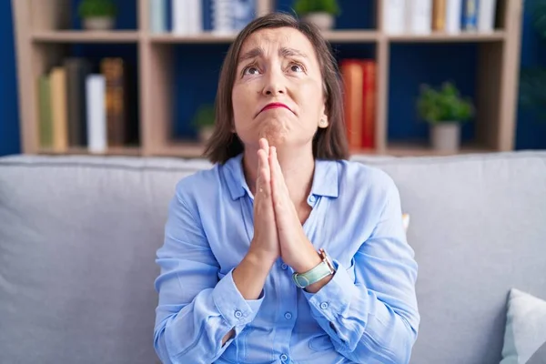 Middle Age Hispanic Woman Sitting Sofa Home Begging Praying Hands — Stock Photo, Image