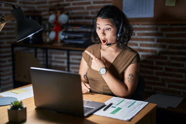 Young Hispanic Woman Working Office Night Surprised Pointing Finger Side —  Fotos de Stock