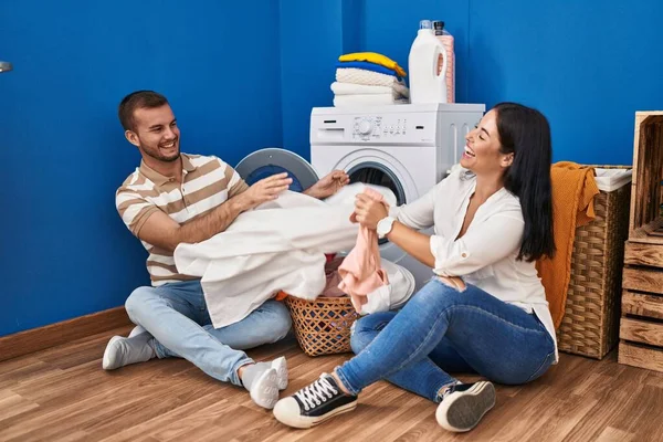 Man Woman Couple Smiling Confident Playing Fighting Clothes Laundry Room — 图库照片
