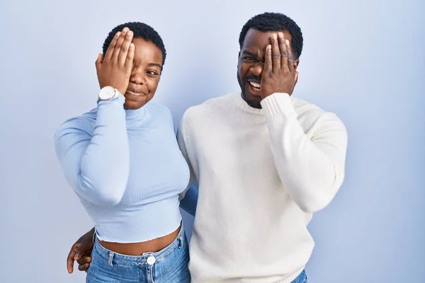 Genç Afro Amerikan Çifti Mavi Arka Planda Duruyor Bir Gözünü — Stok fotoğraf