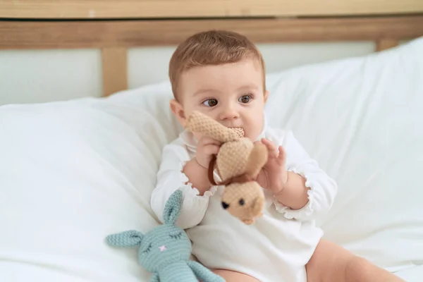 Sevimli Bebek Yatakta Oturmuş Yatak Odasında Bebek Isırıyor — Stok fotoğraf