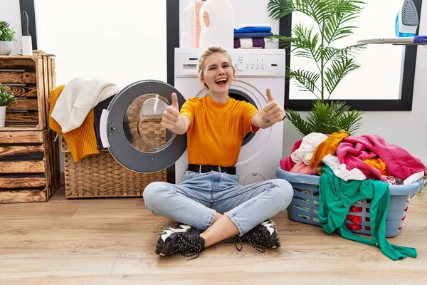 Çamaşır Makinesinin Yanında Oturan Genç Sarışın Kadın Hareketlerini Onaylıyor Gülümsüyor — Stok fotoğraf