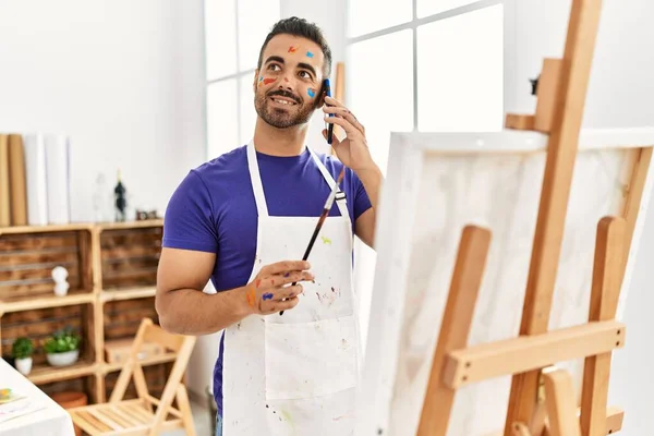 Young Hispanic Man Smiling Confident Talking Smartphone Drawing Art Studio — Foto de Stock