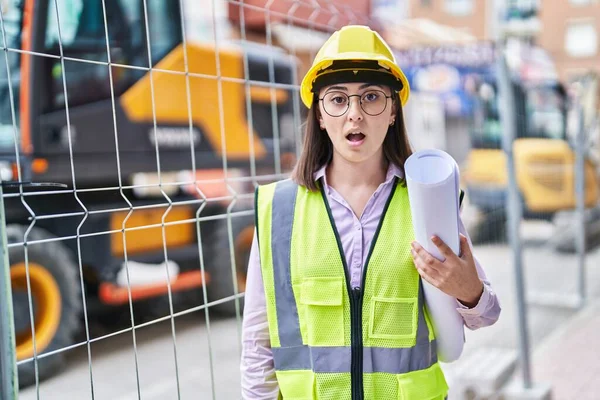 Hispanic Girl Wearing Architect Hardhat Construction Site Scared Amazed Open — Stockfoto
