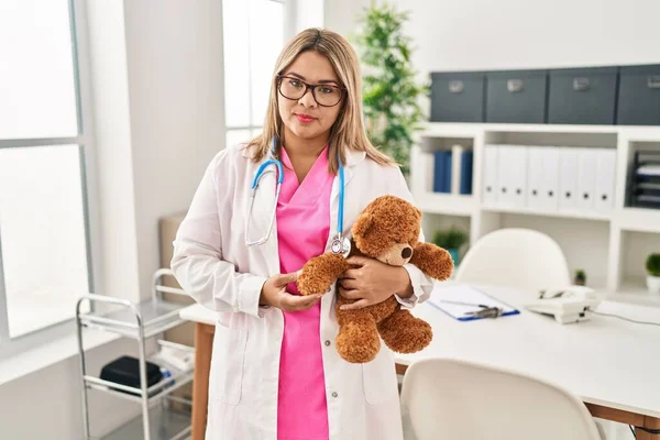 Young Hispanic Doctor Woman Holding Teddy Bear Thinking Attitude Sober — Zdjęcie stockowe