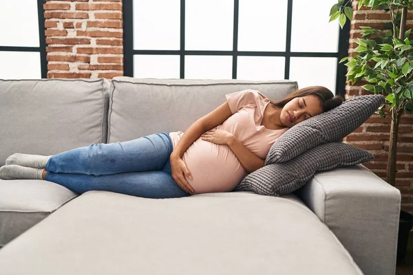 年轻的拉丁女人怀孕了睡在家里的沙发上 — 图库照片
