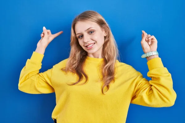 Young Caucasian Woman Standing Blue Background Smiling Amazed Surprised Pointing — Φωτογραφία Αρχείου