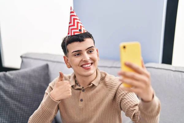 Non binary person celebrating birthday doing video call smiling happy and positive, thumb up doing excellent and approval sign