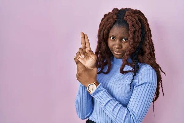 African Woman Standing Pink Background Holding Symbolic Gun Hand Gesture — Stockfoto