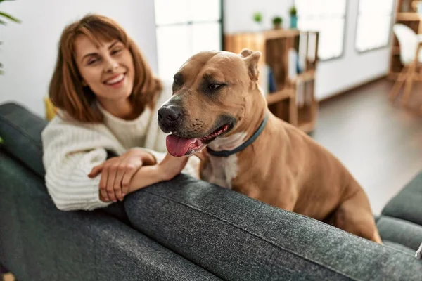 Jonge Kaukasische Vrouw Glimlachen Zelfverzekerd Zitten Bank Met Hond Thuis — Stockfoto