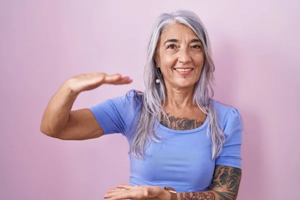 Medelålders Kvinna Med Tatueringar Står Över Rosa Bakgrund Gester Med — Stockfoto